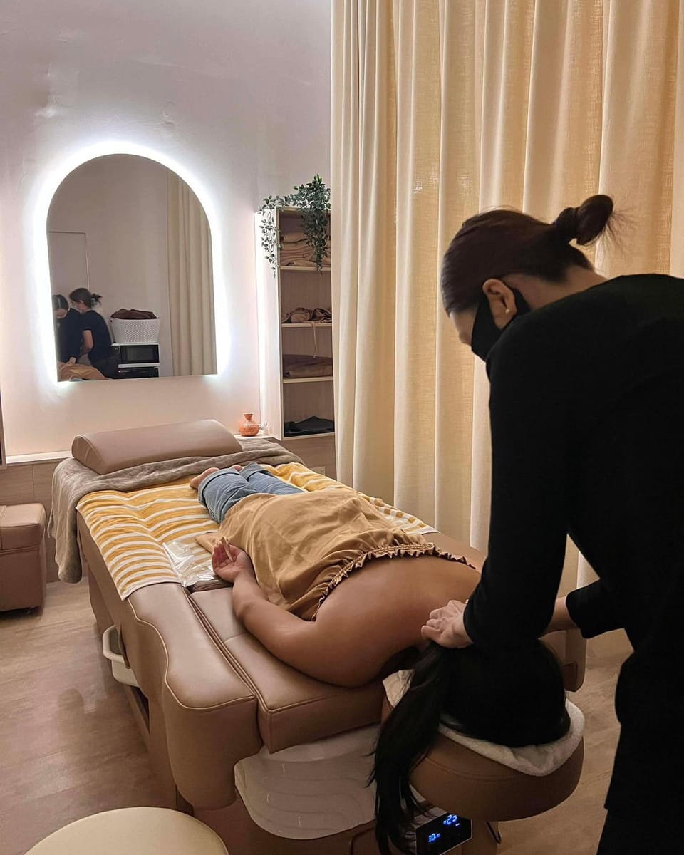 A client on the head spa bed in one of L’mour’s curtained treatment rooms